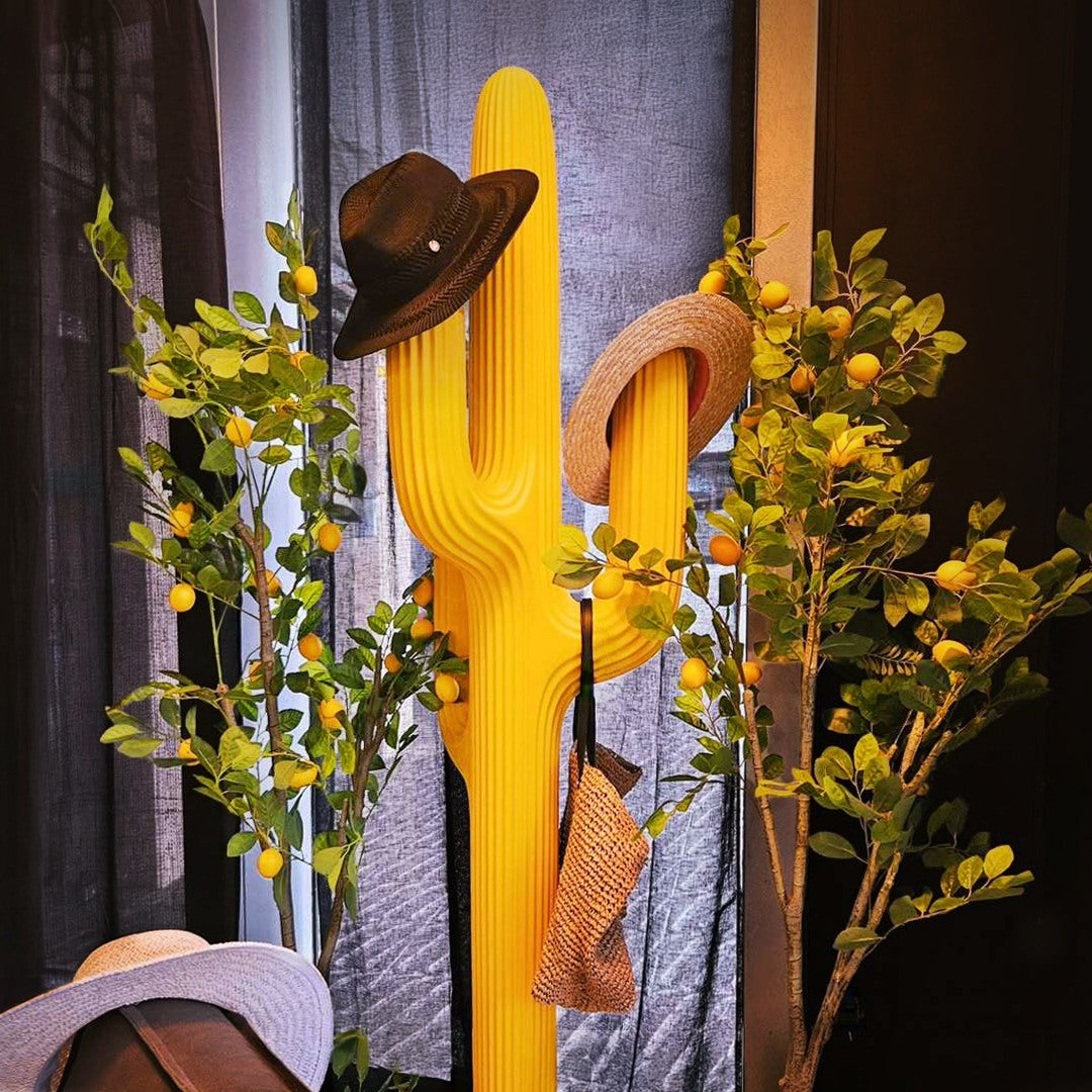 Yellow Saguaro Coat Rack styled with hat and flowers, decorative cactus‑shaped design piece for modern interiors.