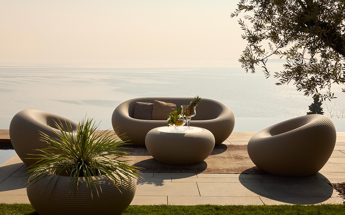 Qeeboo Nami Planter in outdoor lifestyle scene with modern seating and greenery
