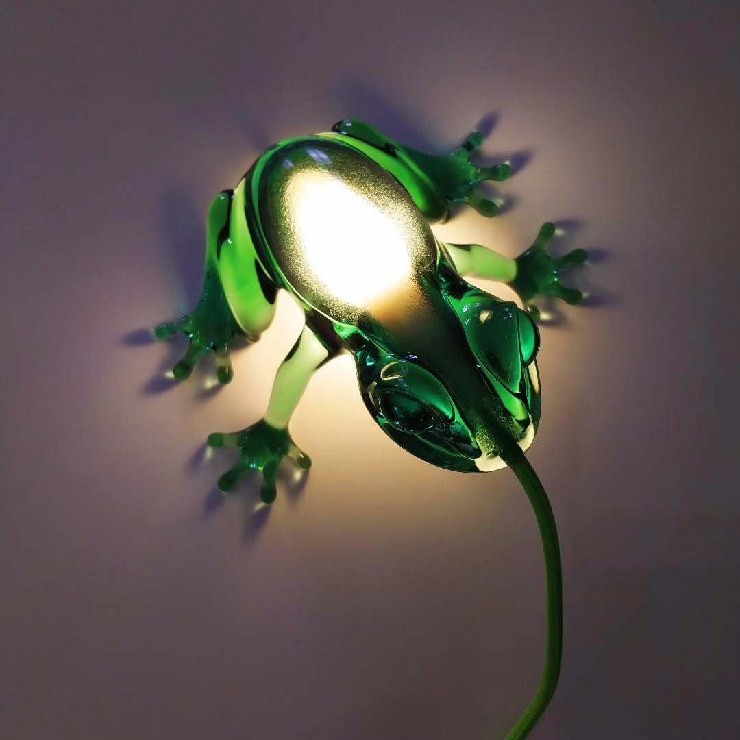 Sculptural frog lamp appearing to eat the LED light by Qeeboo