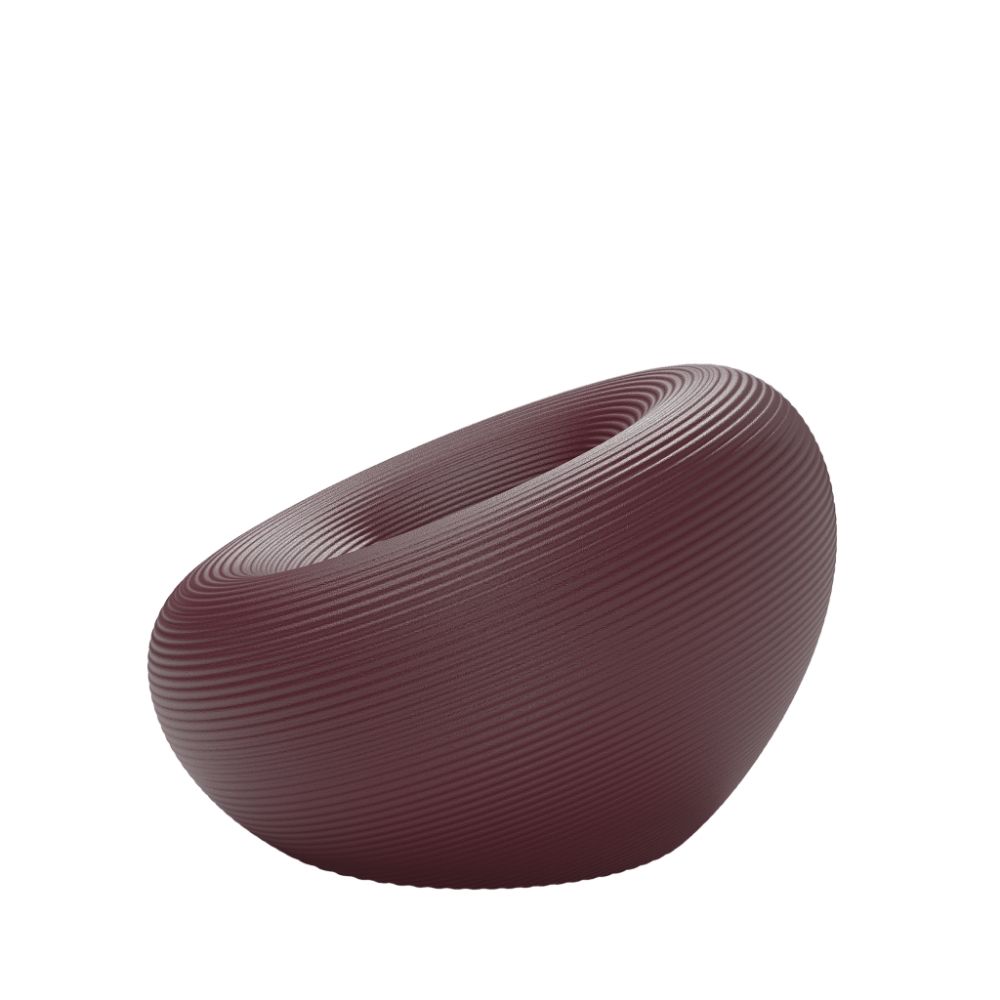 Qeeboo Nami Outdoor Armchair in sculptural wave‑inspired form with ribbed texture in deep burgundy color