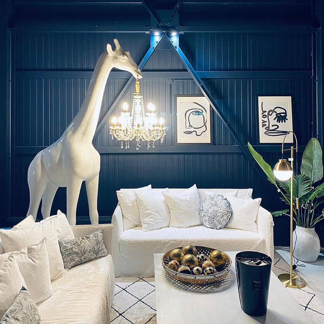 Multiple giraffe-shaped floor lamps holding chandeliers displayed in various interiors